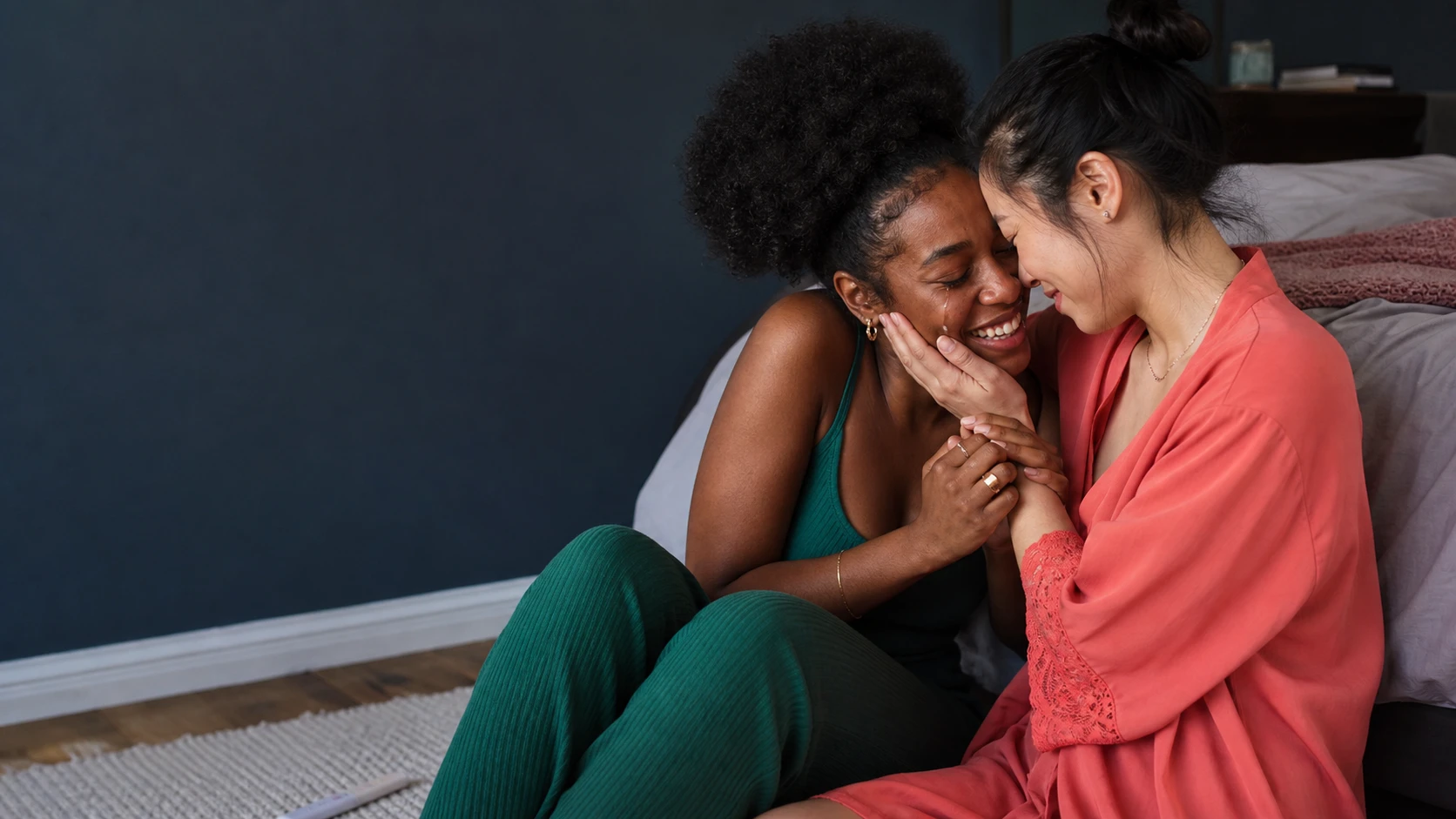 Two women laughing together in a relaxed home setting